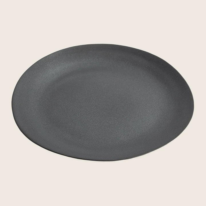 Minimalist matte black plate with sleek design for versatile dining.