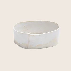 Versatile white ceramic dish, showing signs of use and wear.