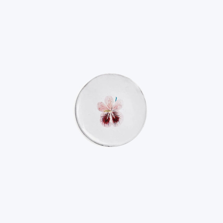 Minimalist round object with delicate pink flower illustration on top