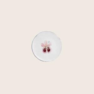 Minimalist round object with delicate pink flower illustration on top