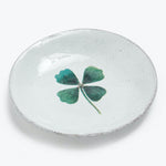 Handcrafted ceramic dish with rustic charm features a lucky four-leaf clover.
