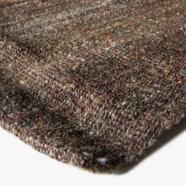 Close-up of a textured, speckled brown fabric or carpet.