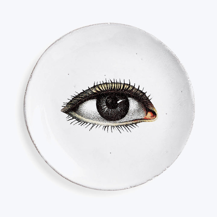 Handmade white plate with detailed realistic human eye illustration.