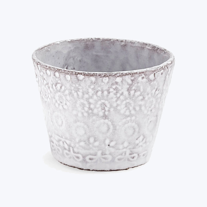 Handcrafted ceramic pot with textured design against white background.