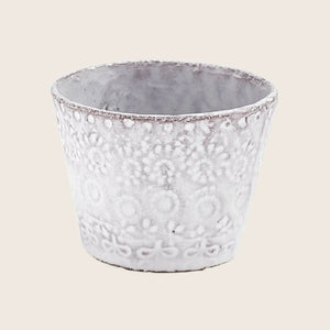Handcrafted ceramic pot with textured design against white background.