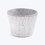 Handcrafted ceramic pot with textured design against white background.