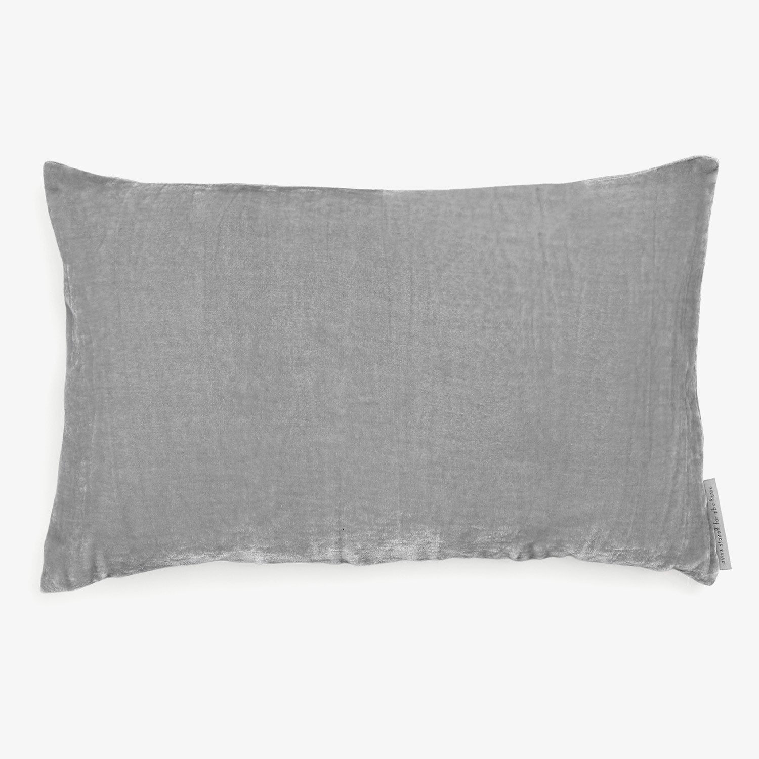 Rectangular gray linen pillow with soft, textured fabric cover and label.