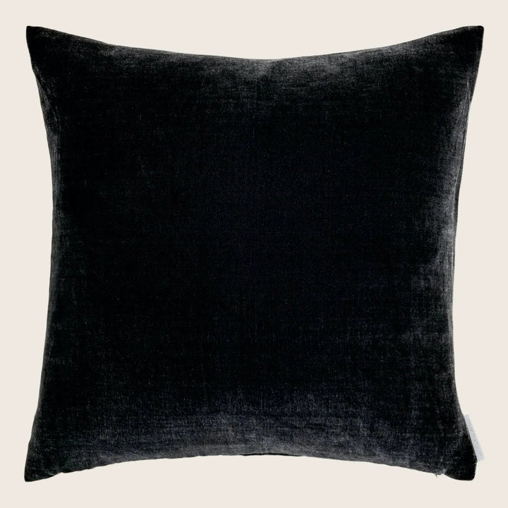 Square black velvet pillow with raised border and tag.