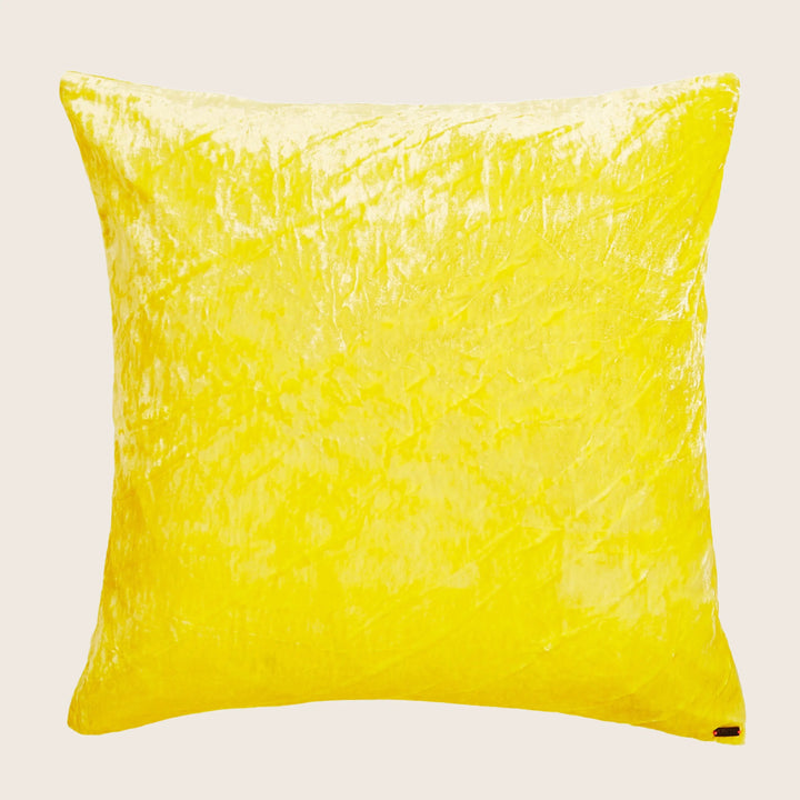 Bright yellow decorative pillow with crinkled texture against white background.