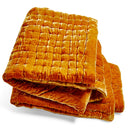 Folded orange velvet quilt with quilted design for ultimate comfort.