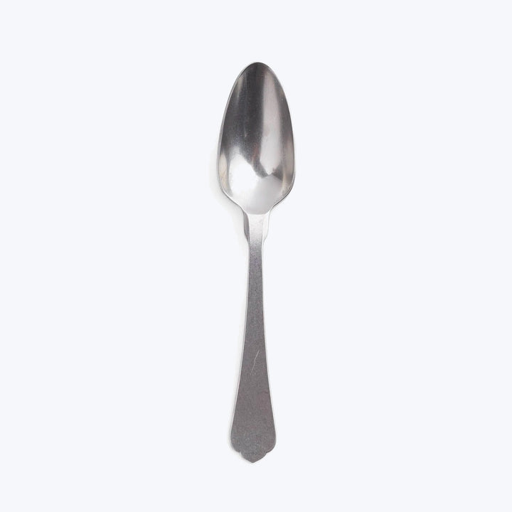 Single stainless steel spoon on white background, minimalist design, polished