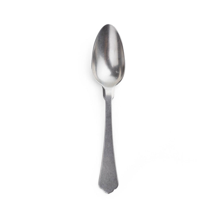A stainless steel spoon standing upright on a white background.