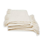 Cozy cream throw blanket with fringed edges offers warmth and style.