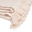 Soft and cozy cream blanket with decorative fringe detail.