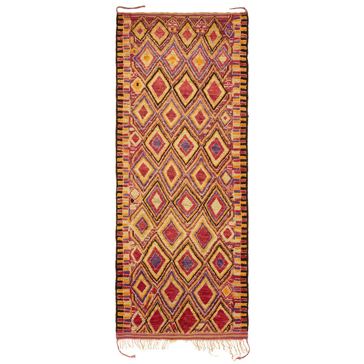 Vibrant handwoven rug showcases intricate diamond pattern and rich colors.