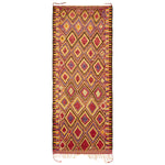Vibrant handwoven rug showcases intricate diamond pattern and rich colors.