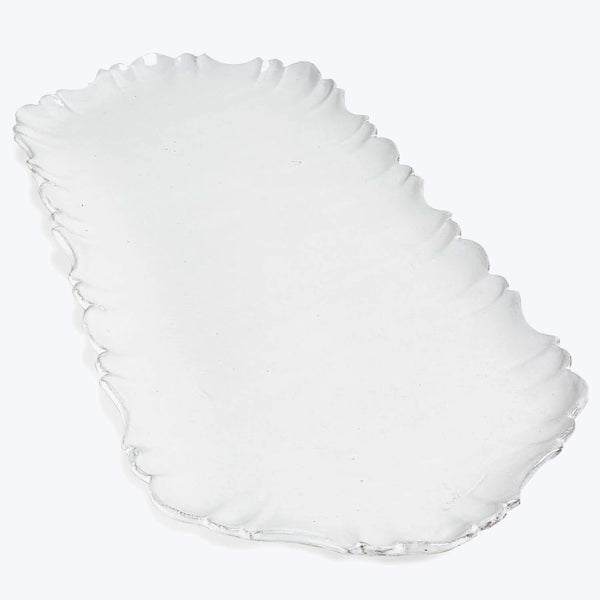 Elegant glass dish with scalloped edge design on white background.