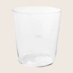 Clear glass tumbler on a white background, featuring subtle logo.