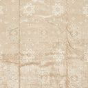 Soft, wrinkled beige fabric with subtle geometric and floral patterns.