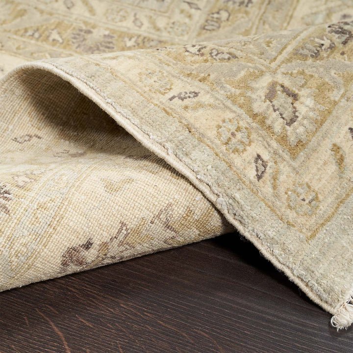 Close-up of a vintage patterned rug with fringed detail.