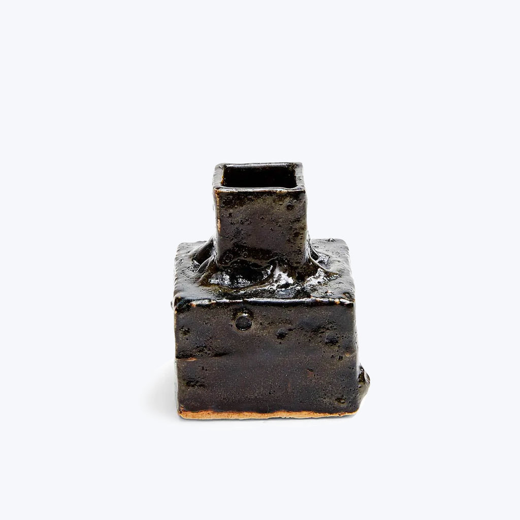 Rusted metal block with a tube-like protrusion on white background.