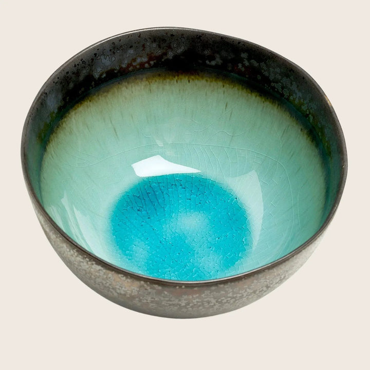 Ceramic bowl with textured glaze transitions from dark to vibrant