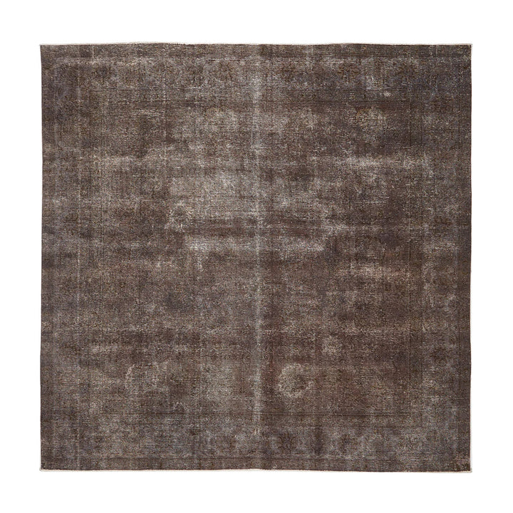 Faded vintage rectangular rug with distressed design in earthy tones.