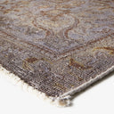 Close-up of an intricately designed, aged-looking rug with frayed edges