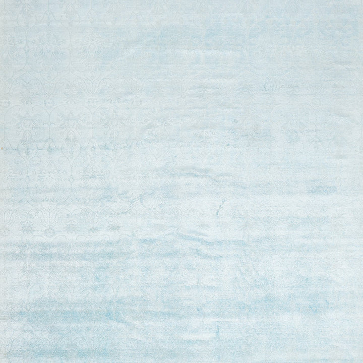 Subtle and vintage-inspired floral pattern on a washed blue surface.