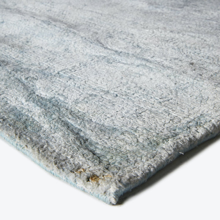 Close-up of a plush gray rug with subtle pattern.