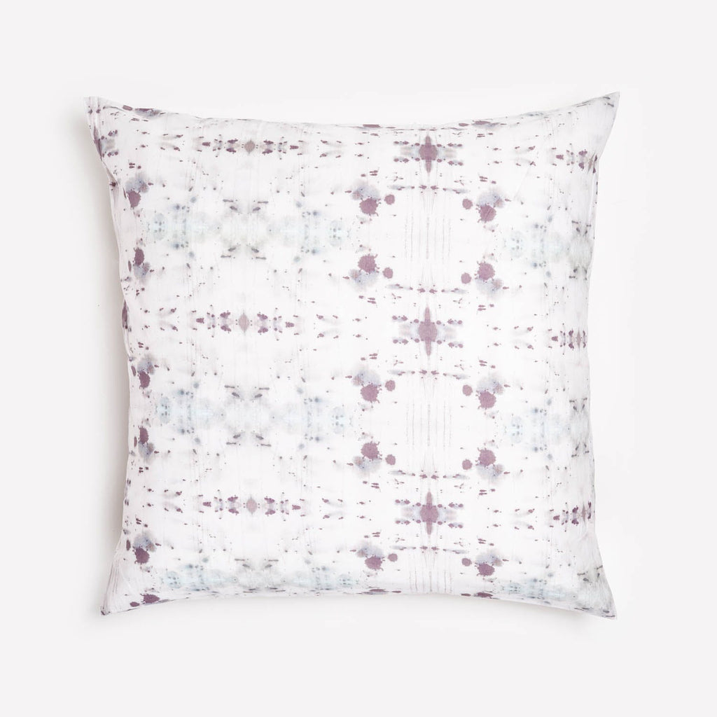 Decorative pillow with abstract spatter pattern in blue and purple.