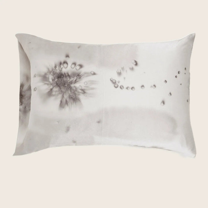 Stained pillow with ink-like blotches creates an abstract pattern.