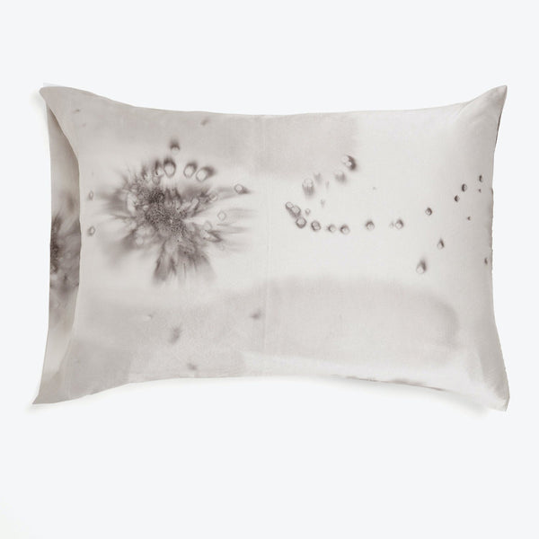 Stained pillow with ink-like blotches creates an abstract pattern.