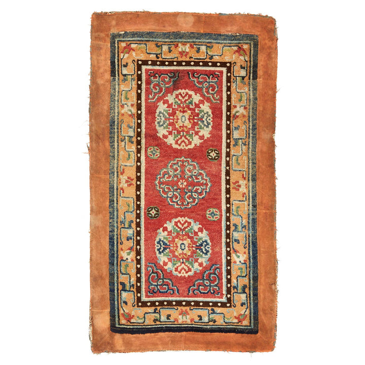 Antique oriental rug with intricate designs in vibrant red and blue.