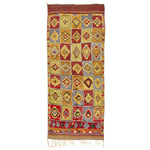 Colorful geometric rug with intricate woven patterns and fringe detail.