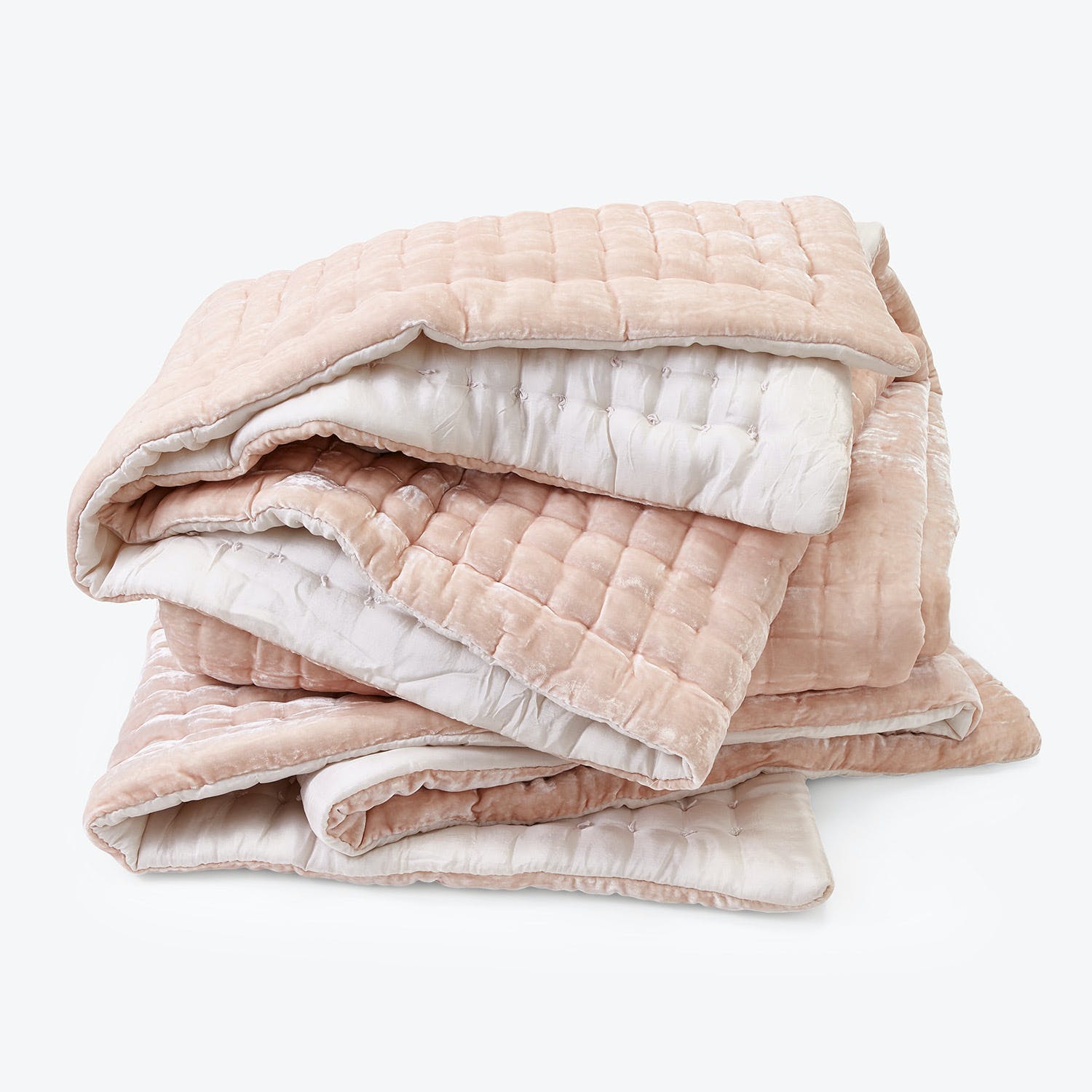 Soft and cozy light pink quilted blanket with textured pattern.