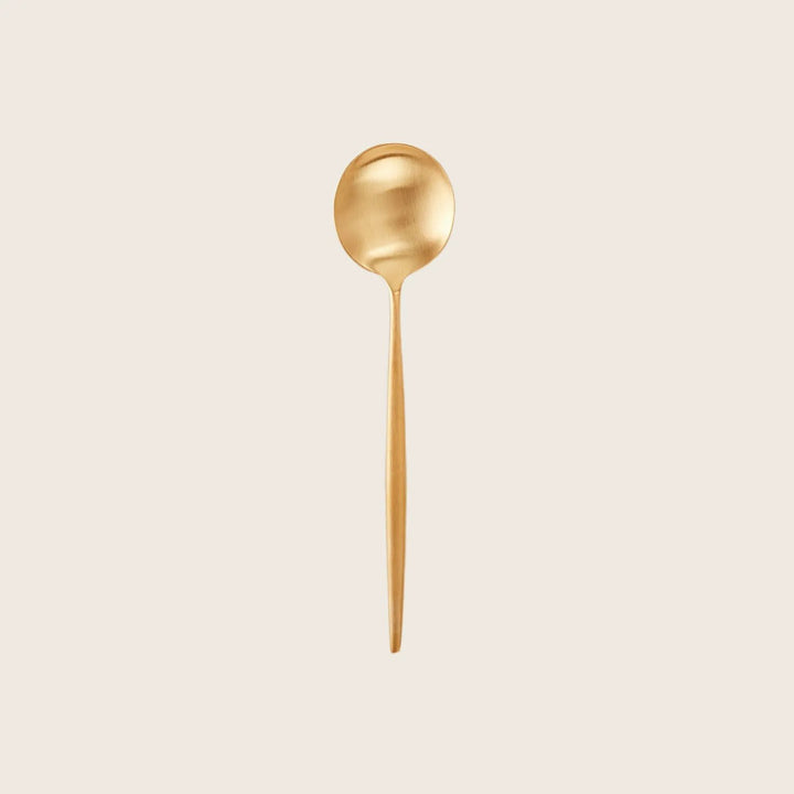 Gold spoon showcases elegant design and minimalist presentation on white.
