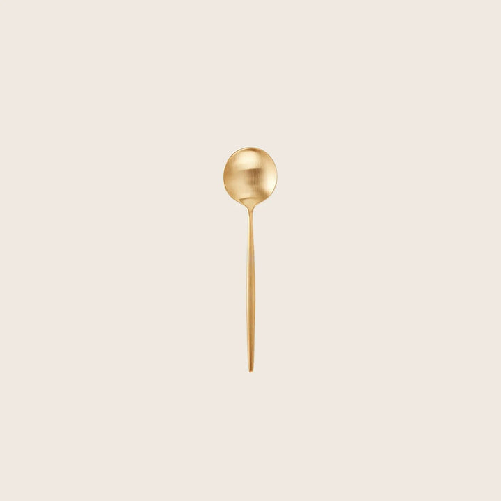 Elegant gold spoon with a matte finish on white background.