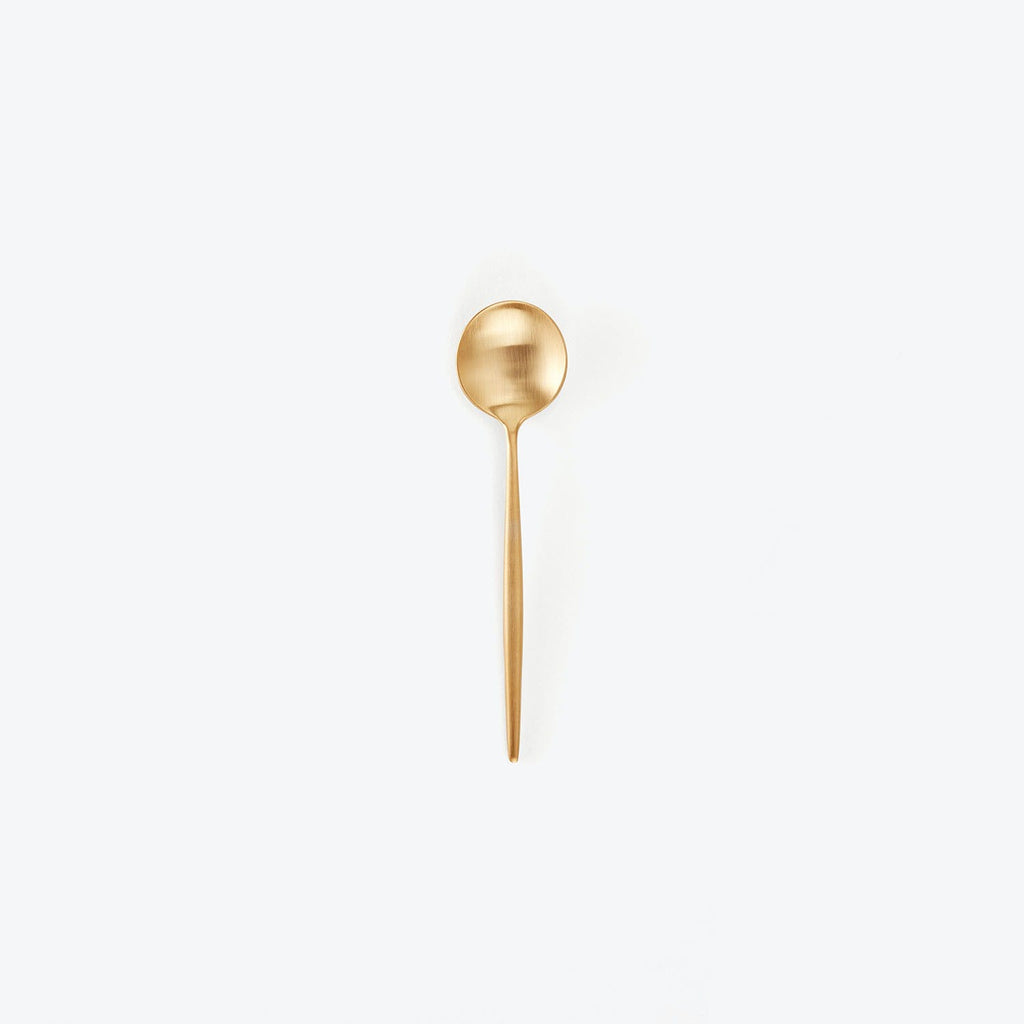 Elegant gold spoon with a matte finish on white background.