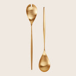 Two modern, golden utensils - slotted and serving spoons.