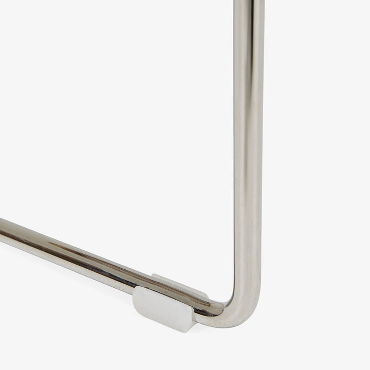 Close-up of metal structure with white protective cap, reflective surface.