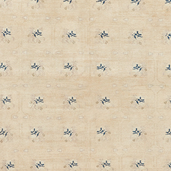 Subtle and symmetrical blue motifs on a light fabric background.