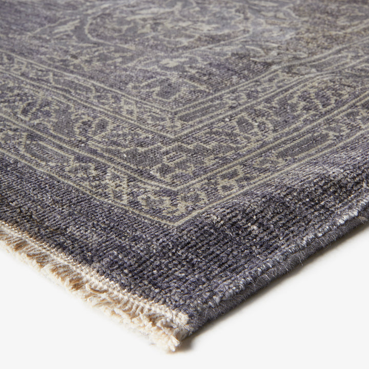 Close-up of a vintage-style rug in shades of grey.
