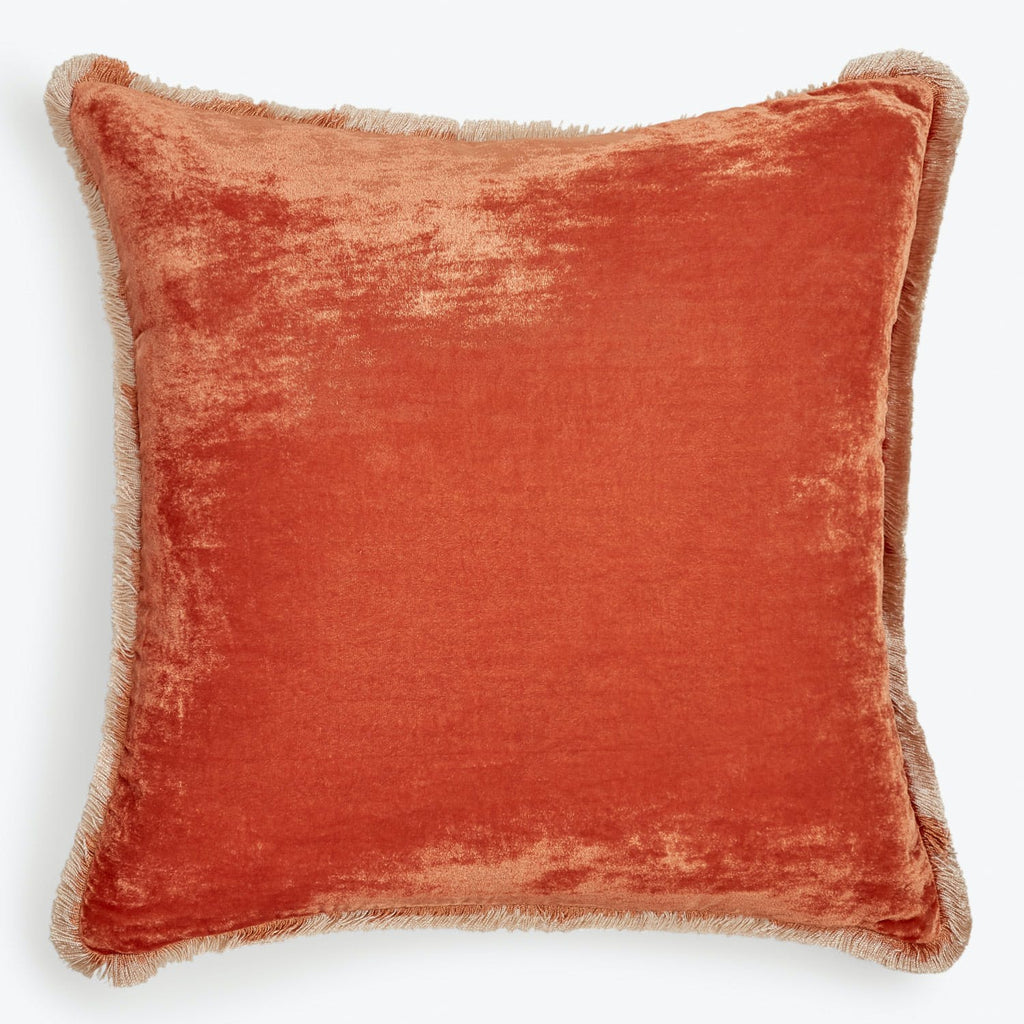 Plush orange decorative pillow with fringe detail adds warmth and style.