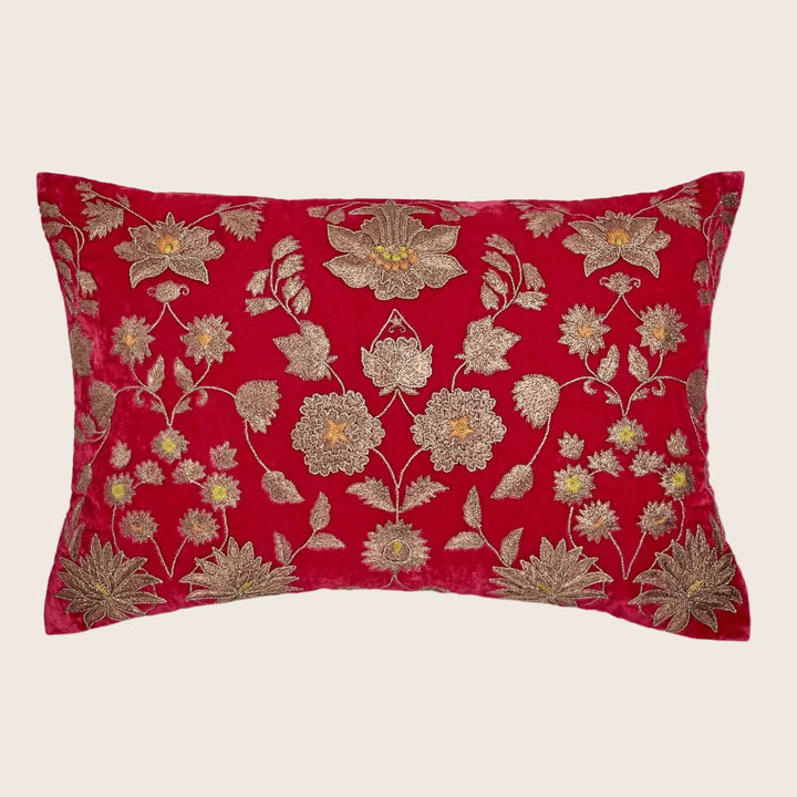 Rectangular red velvet pillow with golden embroidered floral pattern.