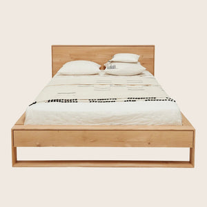 Neatly designed wooden bed with minimalist aesthetic and decorative elements.