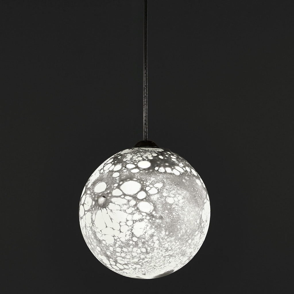 Modern pendant light with intricate network pattern, creating captivating shadows.