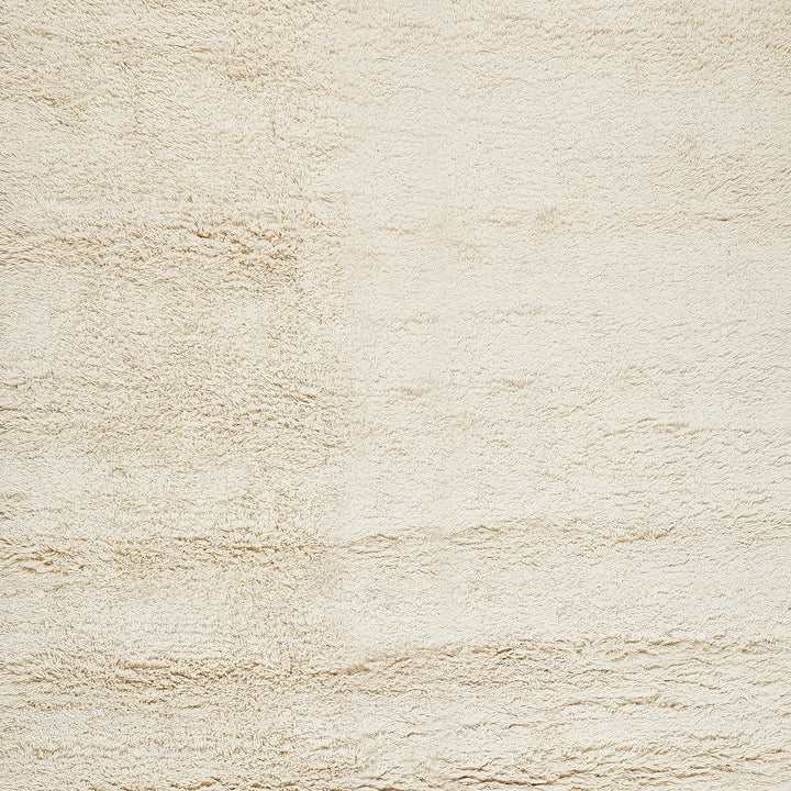 Close-up of a cream-colored, stucco-textured wall or fabric surface.