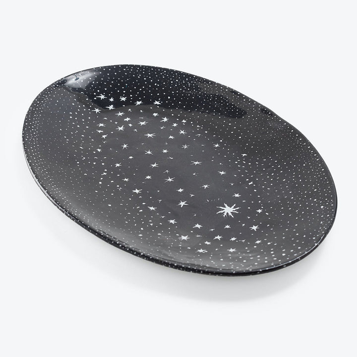 An oval plate resembling a starry night sky with celestial patterns.