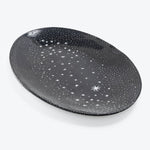 An oval plate resembling a starry night sky with celestial patterns.